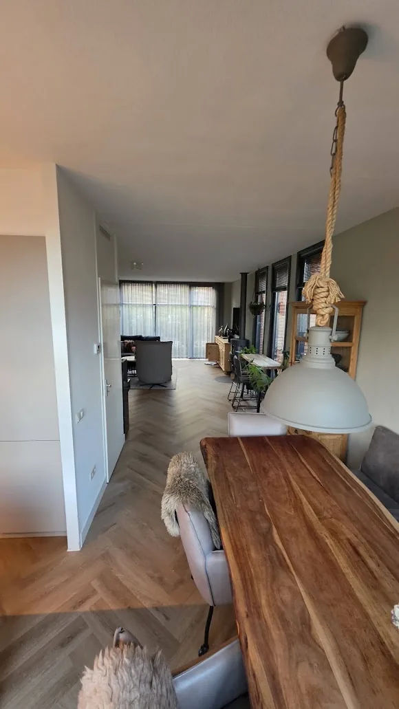 Woonruimte met lichte wanden en een afgewerkte visgraatvloer